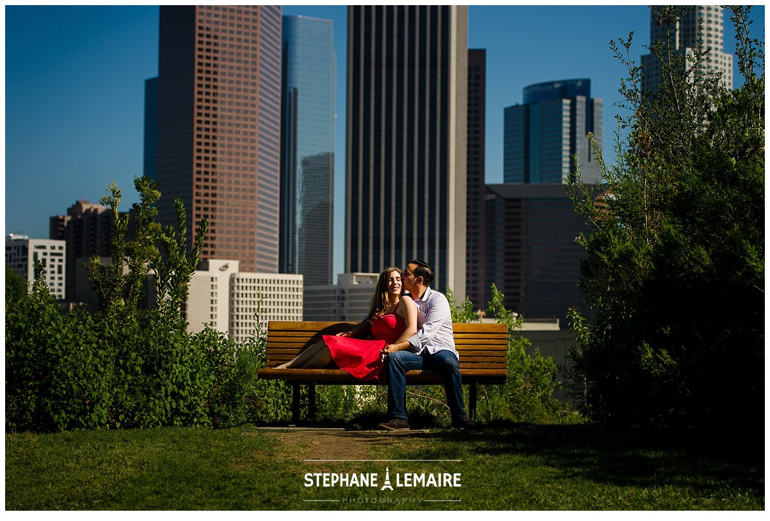 Couple sitting on bench in front of city