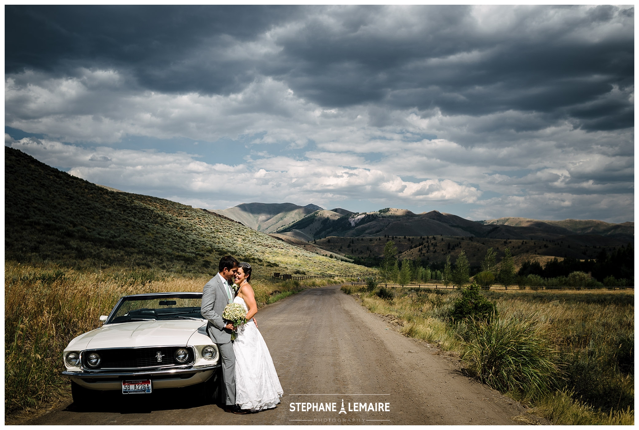 Landscape Portrait- Bride and Groom leaning against white mustang at Sun Valley Wedding