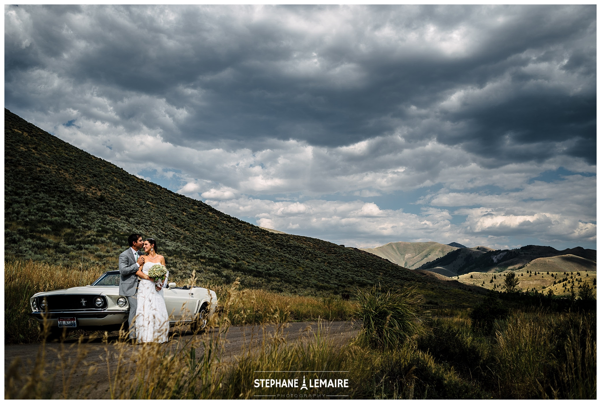 Bride and Groom kissing next to a Ford mustang