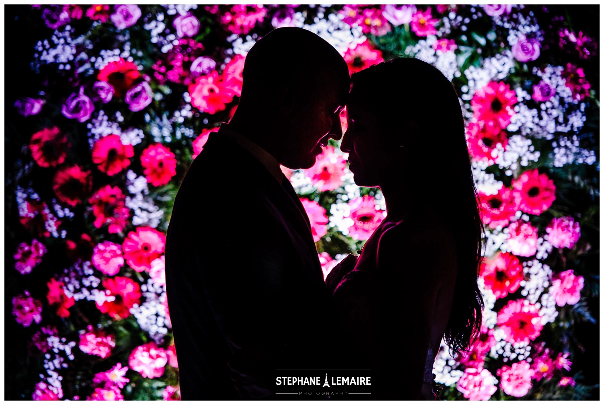 Silhouette shot of Bride and Groom in front of wall flower  at their Jardines Arco Iris wedding