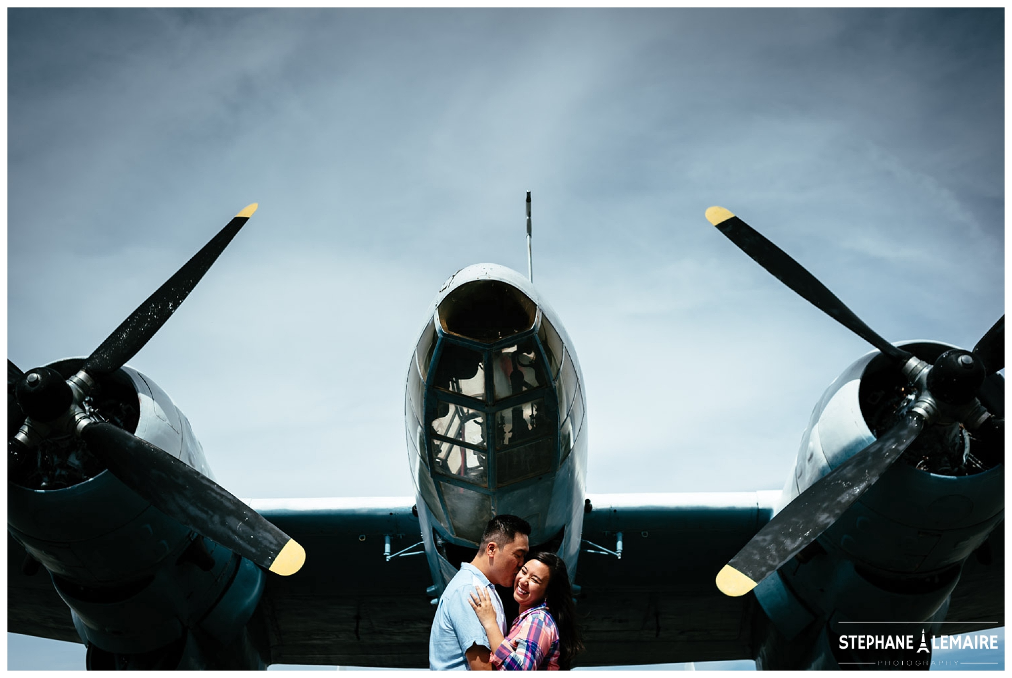 couple kissing under a plane