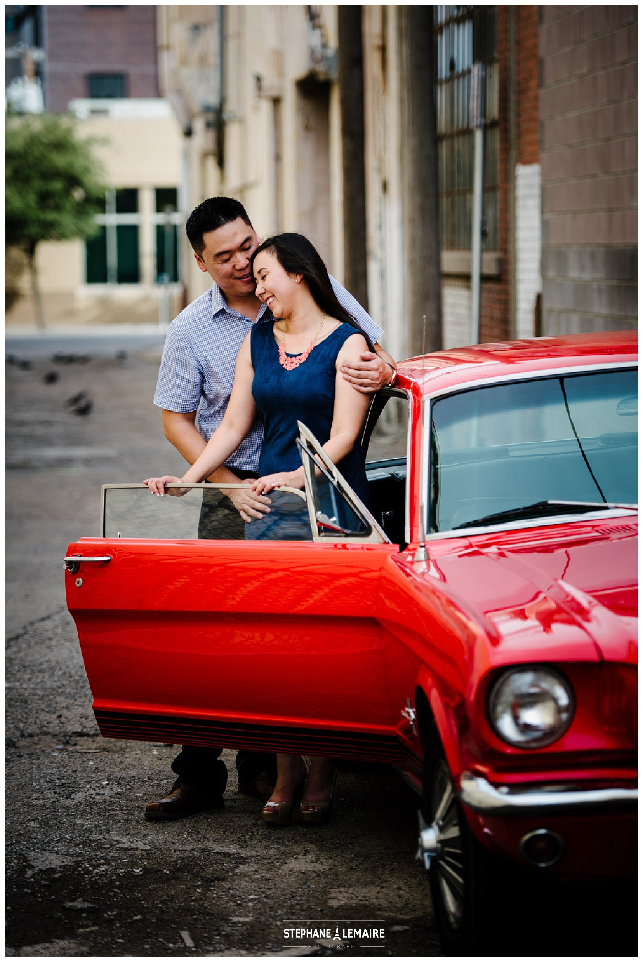 Engaged  couple smiling by the Mustang door