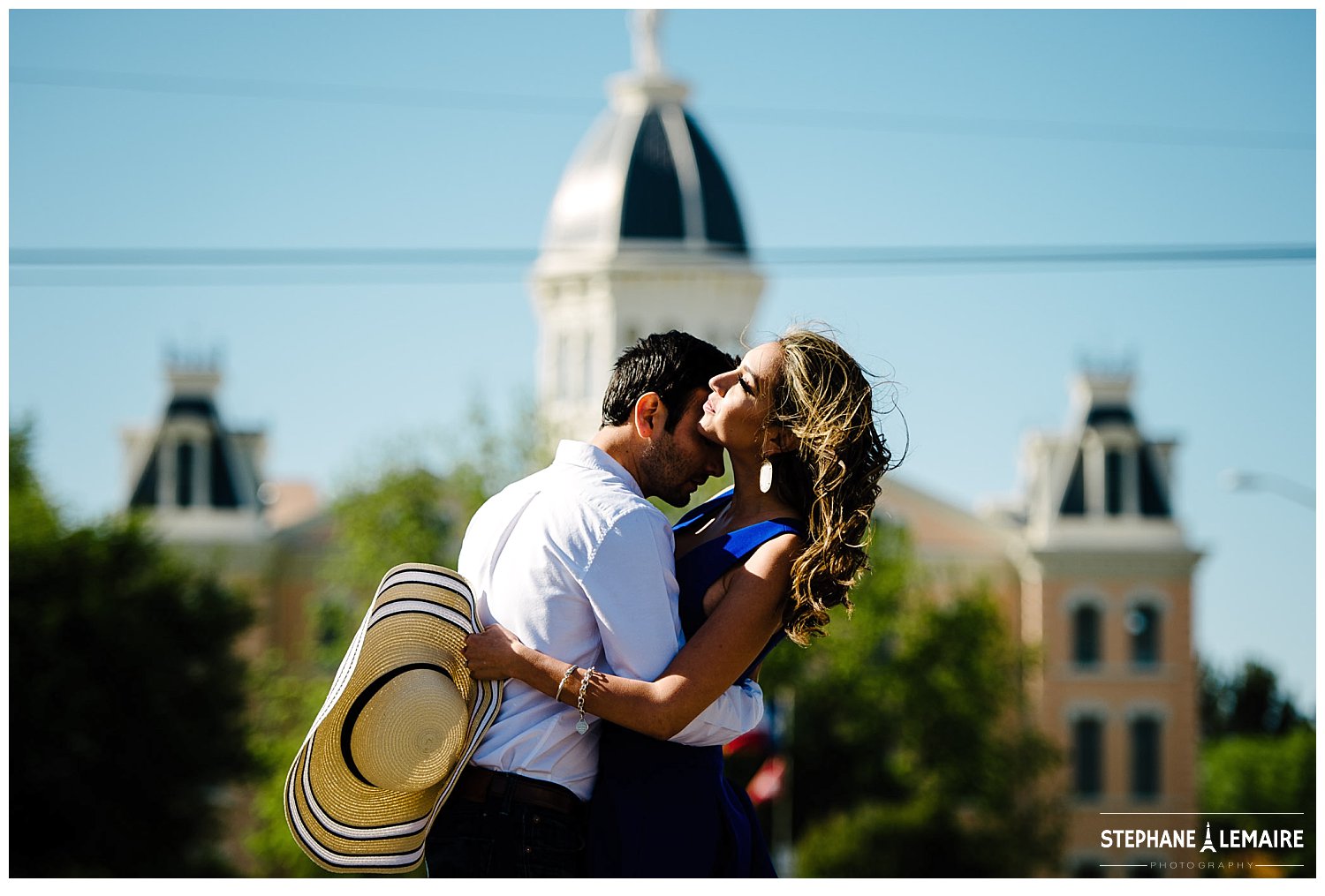 Couple kissing in marfa with city hall behind them.