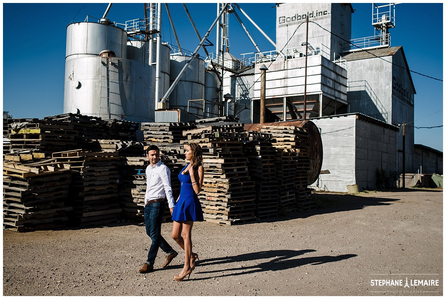 Woman in blue dress dances with fiancé in rustic Marfa.