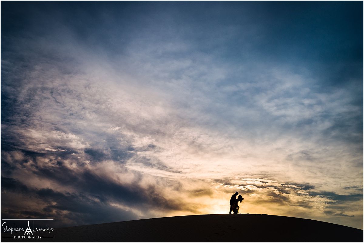 Silhouette of couple at sunset hugging at White Sands National Monument by stephane Lemaire photography
