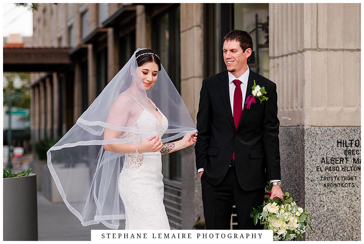 bride and groom kissing in font of  plaza hotel in el paso 
