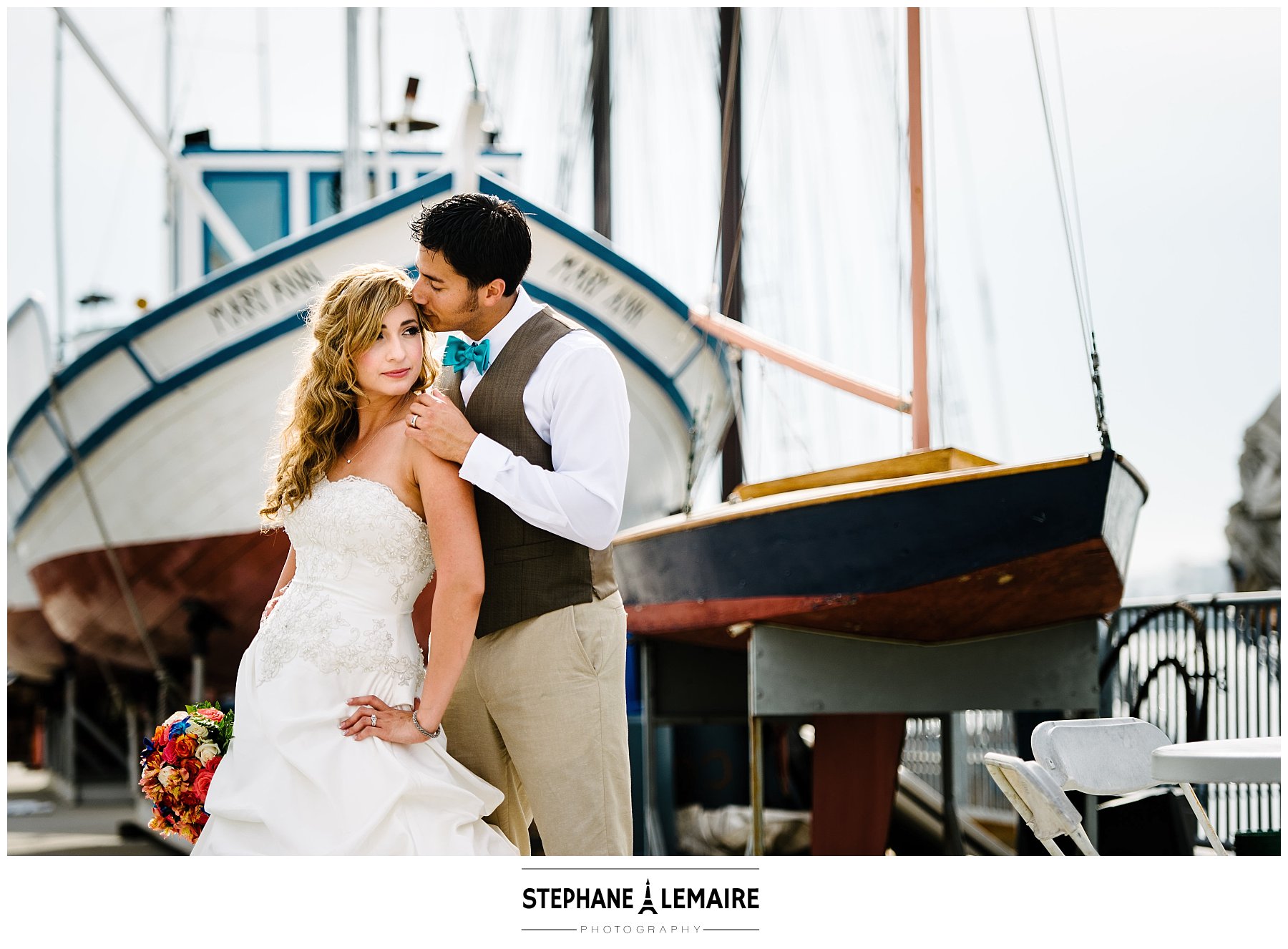 Bride and groom posing in front of a boat