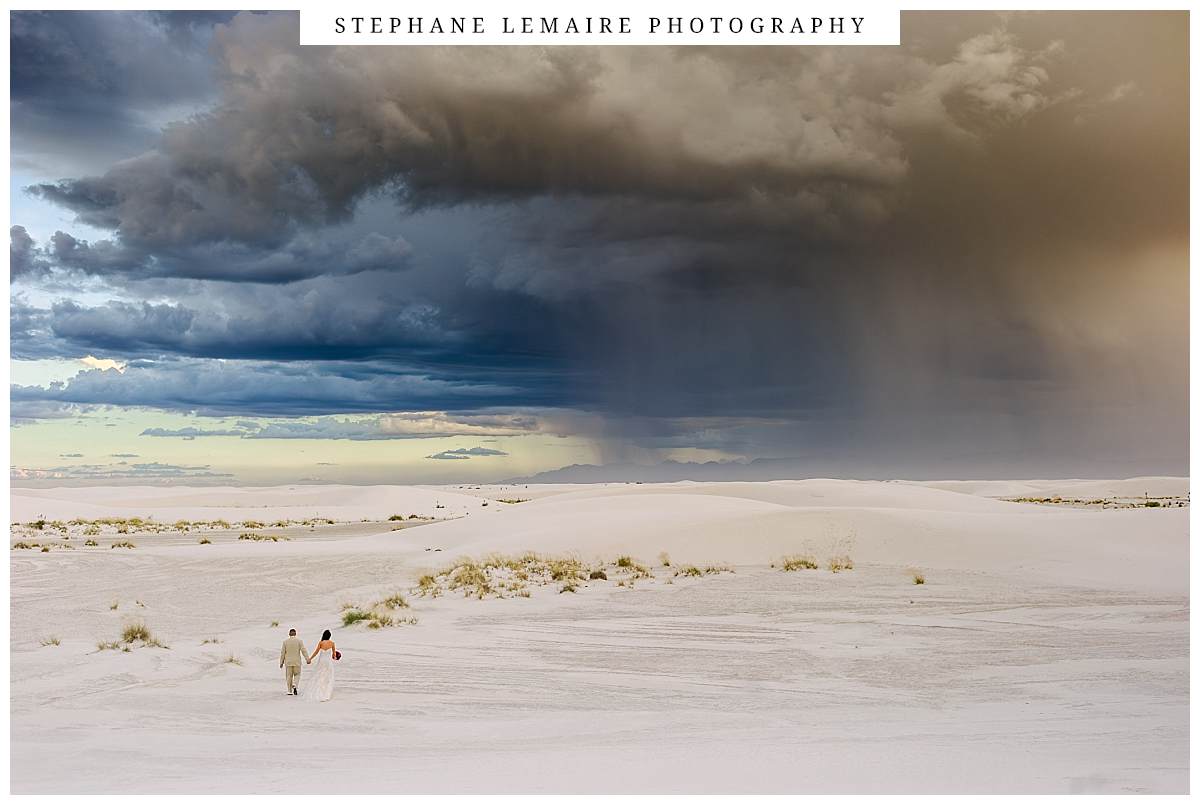bride and groom walking on dunes at white sands
