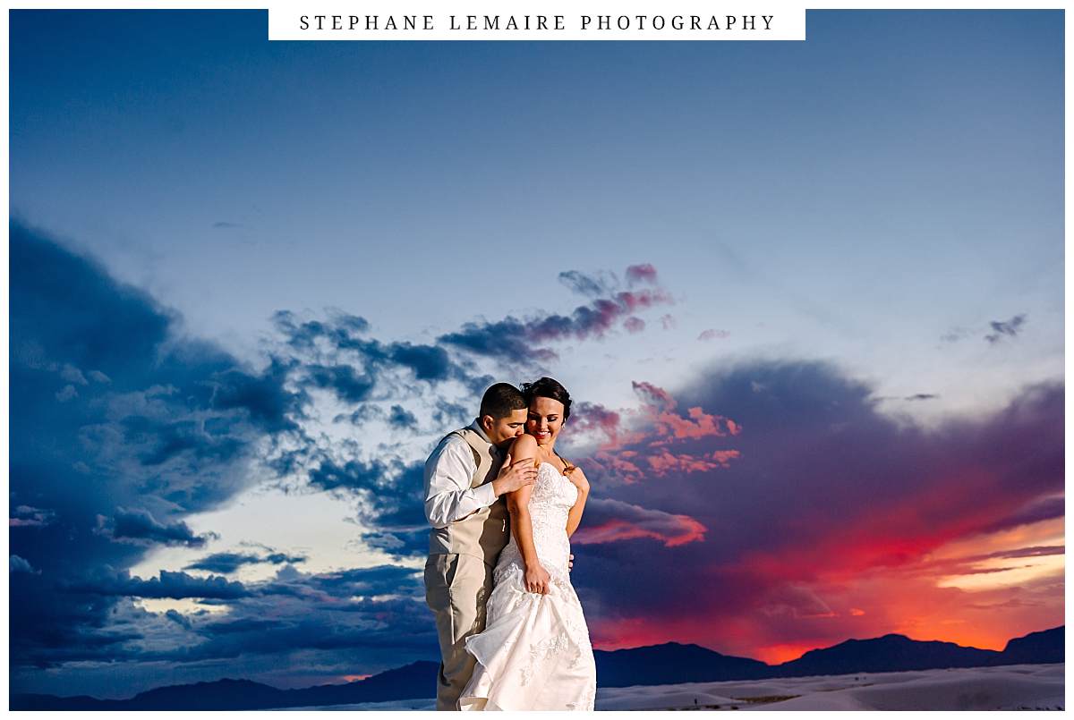 groom kissing bride at sunset during their Wedding at White Sands
