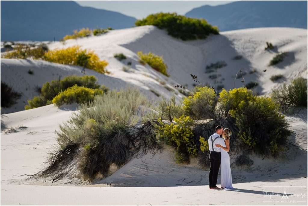 Couple kissing at a white sands elopement photographed by Stephane Lemaire