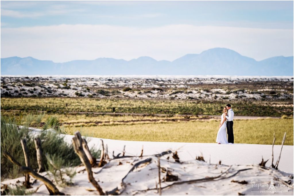 Bride and groom holding each other at  White Sand National monument New Mexico